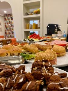 uma mesa coberta com pratos de sanduíches e outros alimentos em Hotel Maïa em Ciutadella