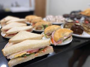 Ein Haufen Sandwiches auf Tellern auf einem Tisch in der Unterkunft Hotel Maïa in Ciutadella