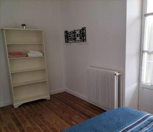 een slaapkamer met een bed en een boekenplank bij Logement entier pour 6 personnes in Saint-Maixent-lʼÉcole