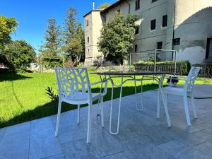 Benevello的住宿－ComeCasa 2 Bedrooms With Garden Apartment，大楼前的两把椅子和一张桌子