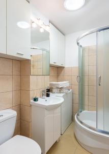 a bathroom with a toilet and a sink and a shower at Grzybowska39 Apartments in Warsaw