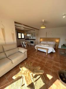ein Wohnzimmer mit einem Bett und einem Sofa in der Unterkunft Vistas Del Maestrazgo apartamentos Rurales in Allepuz