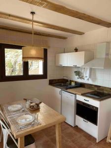 eine Küche mit einem Tisch und einer Arbeitsplatte in der Unterkunft Vistas Del Maestrazgo apartamentos Rurales in Allepuz