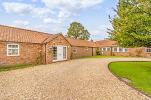 a brick house with a driveway in front of it at The Paddocks Romantic Retreat in Boston