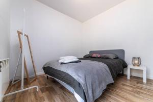 a bedroom with a bed in a white room at Appartement near Disneyland Paris, 2 parking in Torcy
