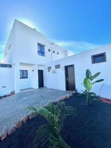 een wit gebouw met twee deuren en een plant bij HOUSE WHITE BEACH in Playa Blanca