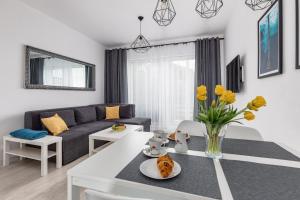 a living room with a couch and a table at Apartament Bursztynowa Przystań in Dziwnówek