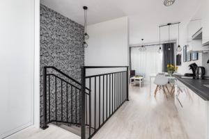 a kitchen and living room with a black iron gate at Apartament Bursztynowa Przystań in Dziwnówek