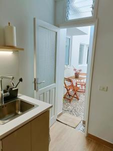 a kitchen with a sink and a door to a table at San Benito 16 in Las Lagunas