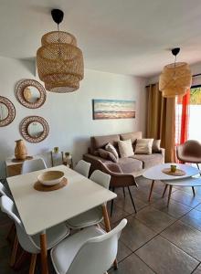 een woonkamer met een bank en een tafel en stoelen bij HOUSE WHITE BEACH in Playa Blanca