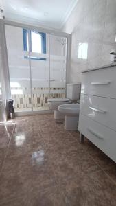 bagno bianco con 2 servizi igienici e lavandino di Casa la Concha Costa Calma a Costa Calma