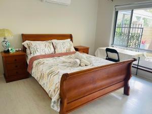 a bedroom with a bed and a table and a window at Comfortable Double room with shared kitchen and bathroom in Perth