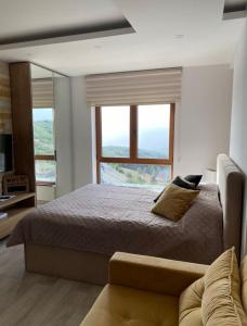 una camera con un letto e una grande finestra di Monte Milmari a Kopaonik