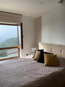 a bedroom with a large bed with a large window at Monte Milmari in Kopaonik