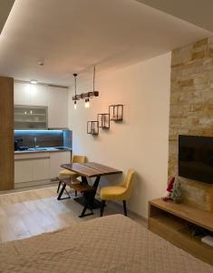 a living room with a table and chairs and a kitchen at Monte Milmari in Kopaonik