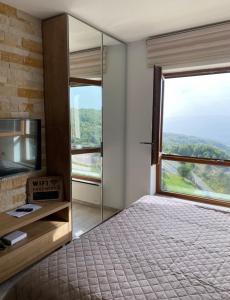 a bedroom with a bed and a large window at Monte Milmari in Kopaonik