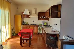 cocina con mesa y mantel rojo en Casa Papa affitti brevi, en Torre Annunziata