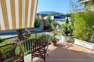 un patio con 2 sillas y plantas en un balcón en Casa Papa affitti brevi, en Torre Annunziata