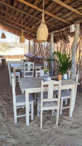 une table et des chaises en bois sous un pavillon dans l'établissement Villa Água Viva, à Itarema