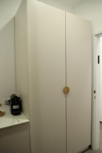 einen weißen Schrank in einem Zimmer mit einer Theke in der Unterkunft חדרי בוטיק B.Y in Bet Scheʼan