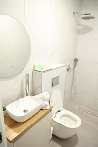 a white bathroom with a sink and a toilet at חדרי בוטיק B.Y in Bet Sheʼan