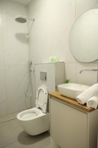 een witte badkamer met een toilet en een wastafel bij חדרי בוטיק B.Y in Bet Sheʼan