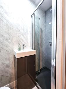 a bathroom with a sink and a shower at Heritage House Apartments in Swindon