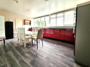 a kitchen with red cabinets and a table and chairs at Heritage House Apartments in Swindon