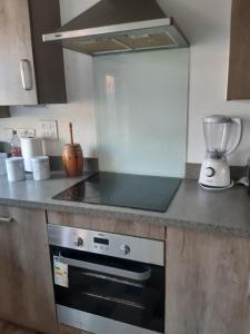 a kitchen with a stove and a blender on a counter at Our Guests in Rushden