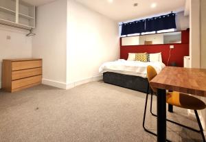 a bedroom with a bed and a wooden table at Heritage House Apartments in Swindon