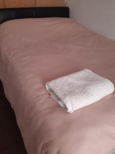 a white towel sitting on top of a bed at Our Guests in Rushden