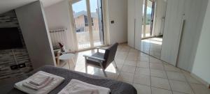 ein Schlafzimmer mit einem Bett und einem Stuhl sowie einem Balkon in der Unterkunft SOLE e MARE Luxury Home in San Salvo