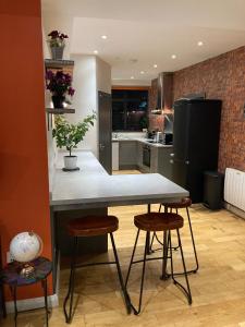 a kitchen with a table and stools in a room at Central Sheffield 3BED 3BATH IV Pent-Apartment in Sheffield