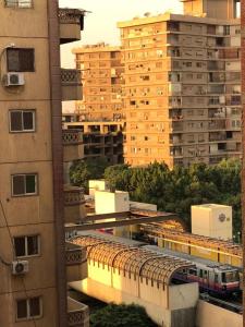 a train on a track in a city with tall buildings at شقة مفروشة in Cairo