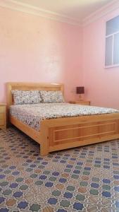 een slaapkamer met een groot houten bed in een kamer bij Villa avec piscine in Essaouira