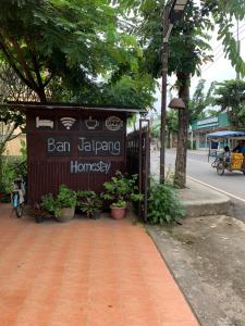 un panneau indiquant un bar suspendu sur le côté d'une rue dans l'établissement ใจแปงโฮมสเตย์ Jaipang Homestay, à Pai