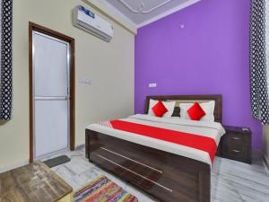 a bedroom with a large bed with purple walls at OYO Flagship Hotel Hastinapur Residency in Jaipur