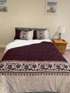 um quarto com uma cama com um edredão roxo e branco em Guest suite Annex private room em Saint Ives