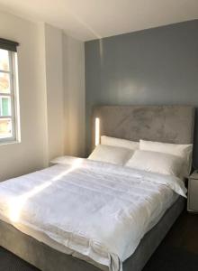 ein großes weißes Bett in einem Schlafzimmer mit Fenster in der Unterkunft Luxury 4 Bedroom Apartment in San Andres + 11 Fotos