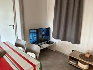 a bedroom with a tv and a bed and a table with chairs at Erreka pays basque in Hasparren