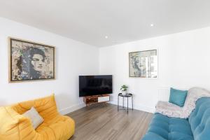 a living room with a blue couch and a tv at Modern 1-bed Central Apartment in Brighton & Hove