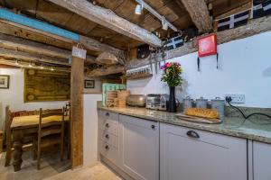 a kitchen with a counter top and a table at Lantau Cottage: Historic Elizabethan house very close to the beach in Looe