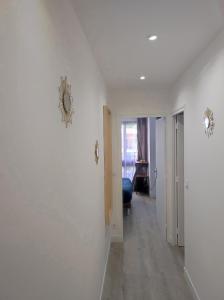 Habitación blanca con pasillo con reloj en la pared en Lumineux Charming Appartement - Cozy Flat, en Le Chesnay