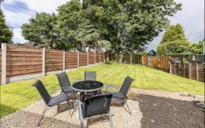 a table and chairs in a backyard with a fence at Come & unwind in Charming 5 Bed House in Blackburn in Blackburn