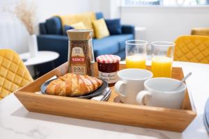 a tray of breakfast food with coffee and croissants at Luxury, free gym, indoor terrace, city centre in Coventry