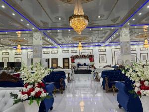 um salão de banquetes com cadeiras azuis e um lustre em Niagara Falls Bahawalpur em Bahawalpur