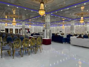 Un salón de banquetes con mesas, sillas y candelabros. en Niagara Falls Bahawalpur, en Bahawalpur
