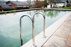 a swimming pool with two metal hand rails next to it at Hotel Tannenhof in Bad Wünnenberg