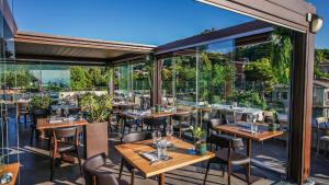 a restaurant with wooden tables and chairs and windows at Drì bed & breakfast in Rocca di Papa