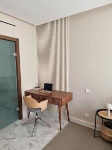 ein Büro mit einem Schreibtisch mit einem Laptop und einem Stuhl in der Unterkunft Superbe appartement avec terrasse in Casablanca